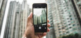 person using iphone camera to take photo of buildings