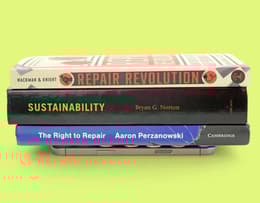 An iPhone facedown with a book on top of it