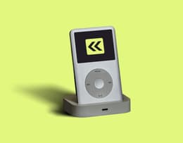 An image of the iPod classic placed in a docking station, connected for charging and syncing.
