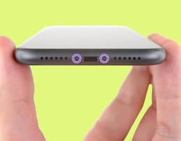 An image of the pentalobe screws on the bottom of an iPhone highlighted