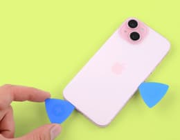 An image of an iPhone screen with several picks inserted beneath the screen