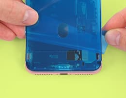 Someone attaching replacement adhesive to an iPhone frame